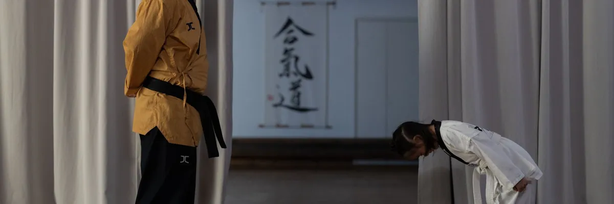 Young karate student bowing to an instructor in a dojo
